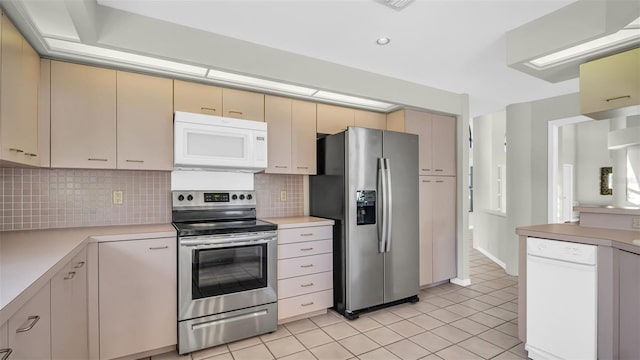 kitchen featuring cream cabinetry, light tile patterned flooring, appliances with stainless steel finishes, and tasteful backsplash