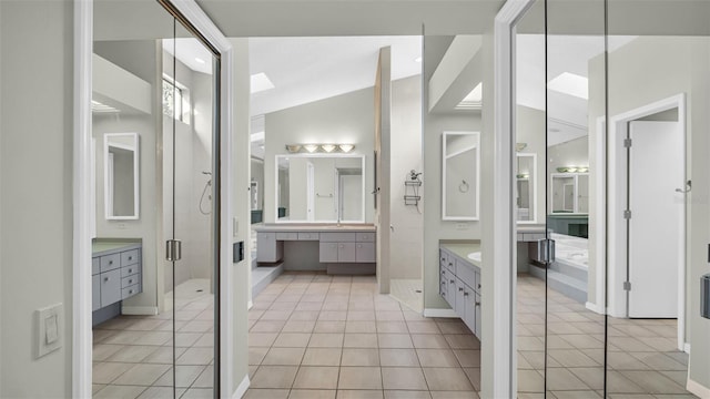 bathroom with tile patterned floors, vanity, a shower with shower door, and lofted ceiling