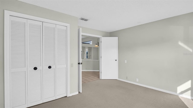 unfurnished bedroom featuring carpet flooring and a closet