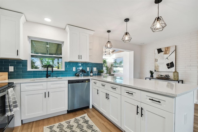 kitchen featuring light wood-type flooring, stainless steel appliances, sink, white cabinetry, and hanging light fixtures