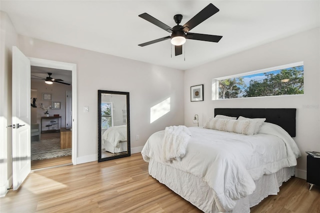 bedroom featuring light hardwood / wood-style floors, multiple windows, and ceiling fan