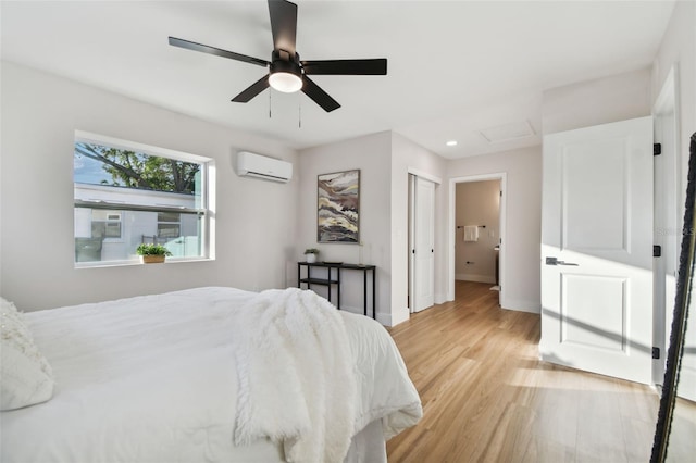 bedroom with a wall unit AC, ceiling fan, and light hardwood / wood-style floors