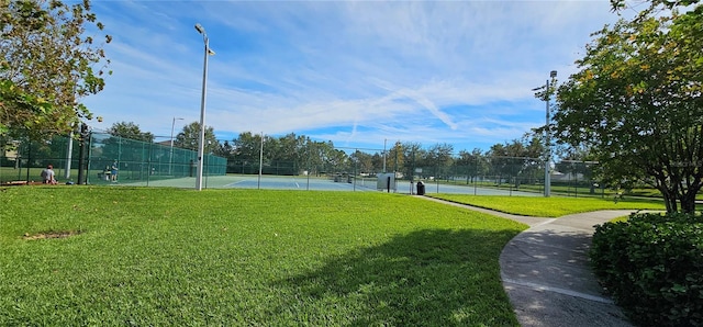 surrounding community featuring a yard and tennis court