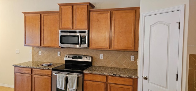 kitchen with decorative backsplash, stainless steel appliances, and dark stone counters