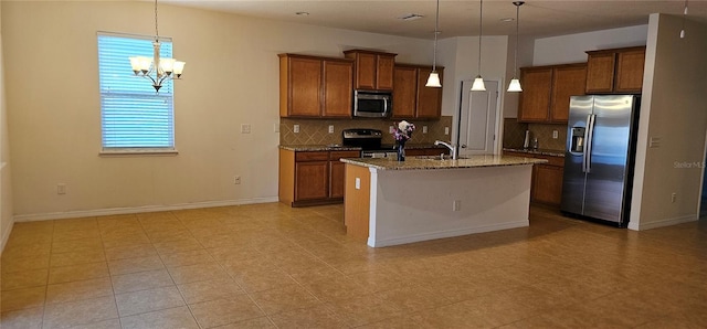 kitchen featuring backsplash, a center island with sink, decorative light fixtures, stainless steel appliances, and a chandelier