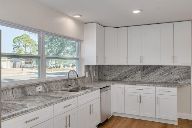 kitchen featuring dishwasher, light hardwood / wood-style floors, white cabinetry, and sink