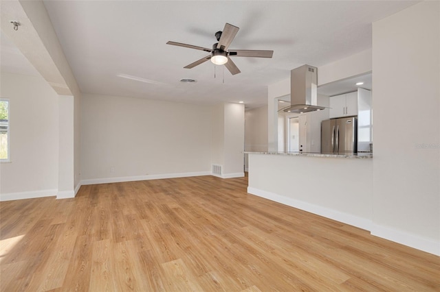 unfurnished living room with ceiling fan and light wood-type flooring