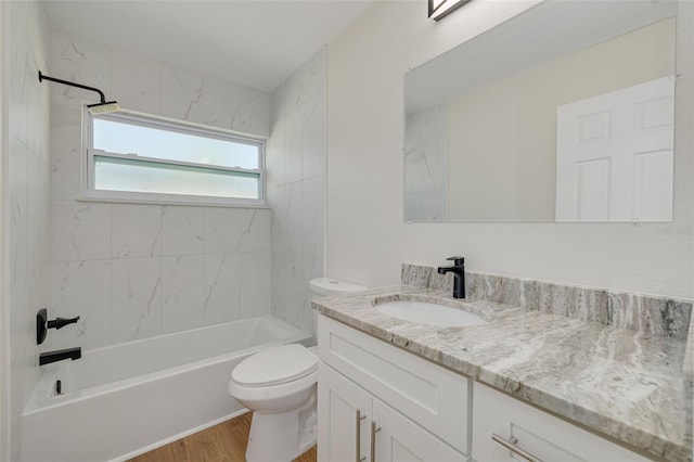 full bathroom with vanity, tiled shower / bath combo, hardwood / wood-style flooring, and toilet