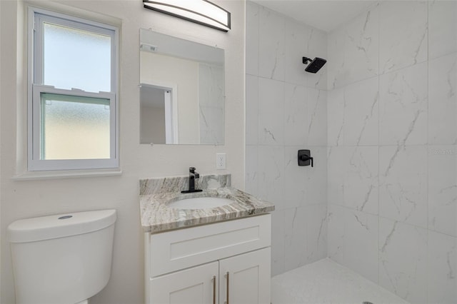 bathroom featuring tiled shower, vanity, and toilet