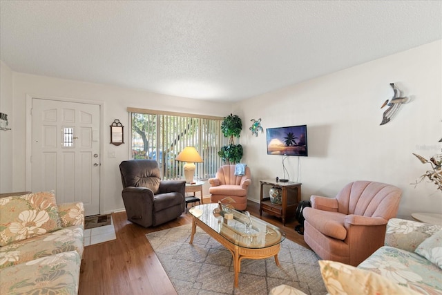 living room with light hardwood / wood-style flooring and a textured ceiling