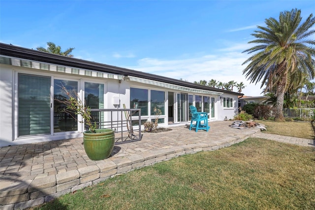 back of house with a patio area and a yard