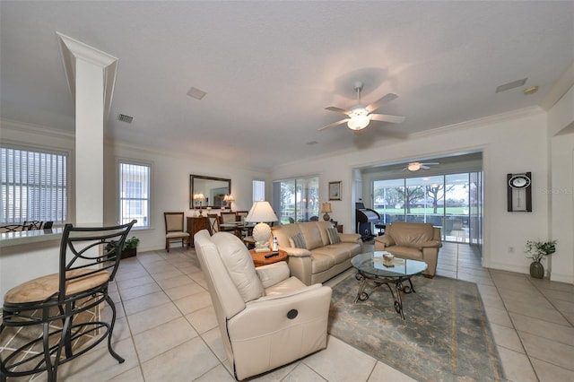 tiled living room with ceiling fan, a healthy amount of sunlight, and ornamental molding