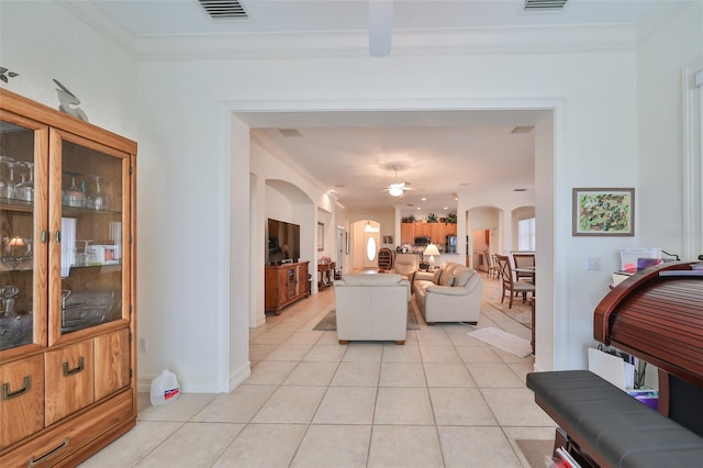 1120 Emerald Dunes Dr, Sun City Center, FL 33573 - living room featuring arched walkways, light tile patterned floors, ornamental molding, a ceiling fan, and baseboards