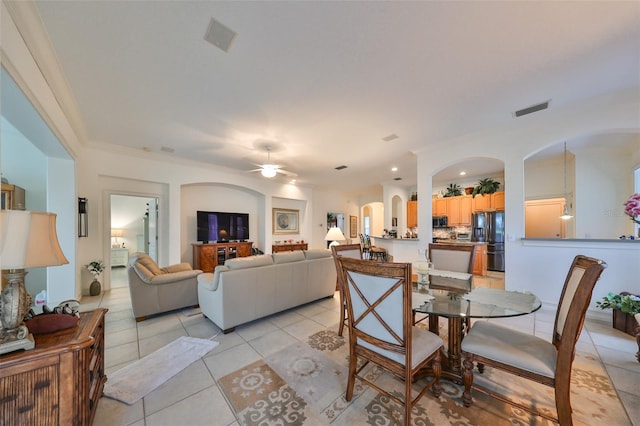 tiled dining room featuring ceiling fan and crown molding