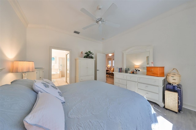 1120 Emerald Dunes Dr, Sun City Center, FL 33573 - bedroom with crown molding, light wood-type flooring, a ceiling fan, ensuite bathroom, and baseboards