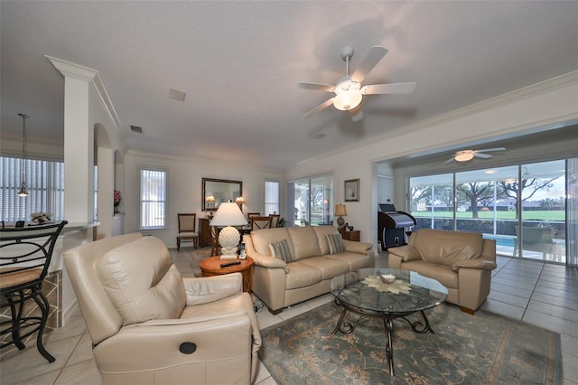 tiled living room with plenty of natural light, ceiling fan, and ornamental molding