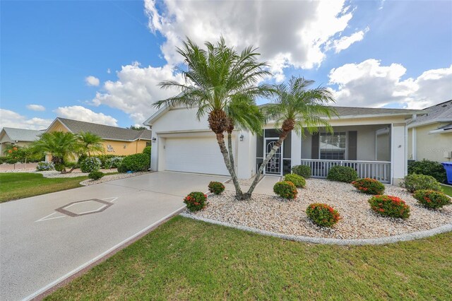 1120 Emerald Dunes Dr, Sun City Center, FL 33573 - ranch-style home featuring an attached garage, a porch, stucco siding, concrete driveway, and a front lawn