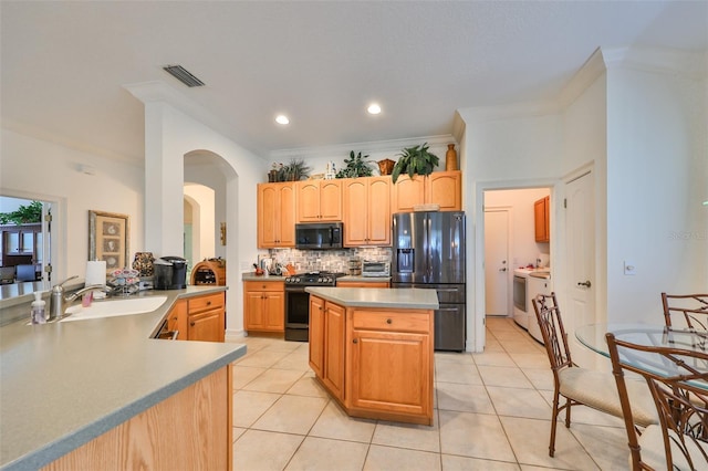 1120 Emerald Dunes Dr, Sun City Center, FL 33573 - kitchen with black appliances, a sink, backsplash, light tile patterned flooring, and a kitchen island