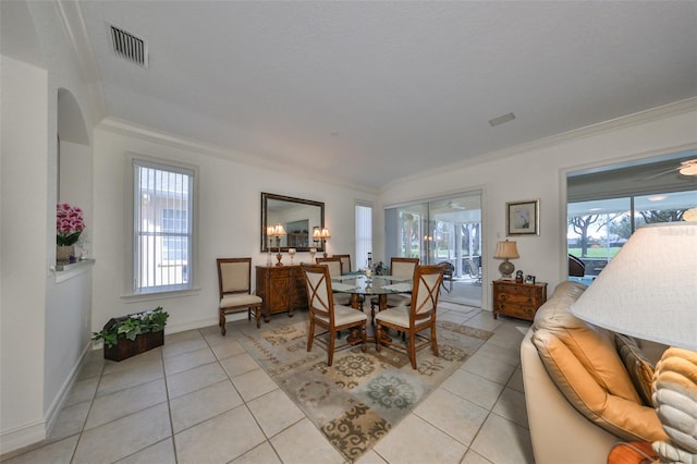 1120 Emerald Dunes Dr, Sun City Center, FL 33573 - dining room featuring crown molding, plenty of natural light, light tile patterned floors, and arched walkways