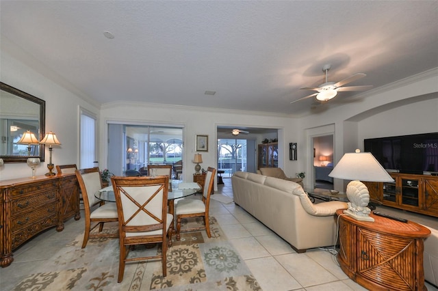 living room featuring light tile patterned floors, ceiling fan, and ornamental molding