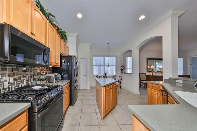 kitchen with pendant lighting, light tile patterned floors, tasteful backsplash, ornamental molding, and gas range