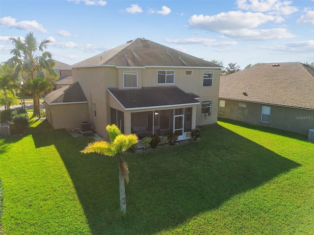 rear view of house featuring a sunroom, cooling unit, and a yard