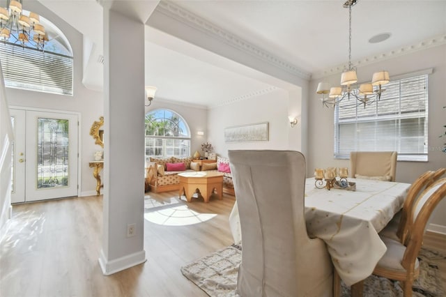 dining space featuring crown molding, light hardwood / wood-style flooring, and an inviting chandelier