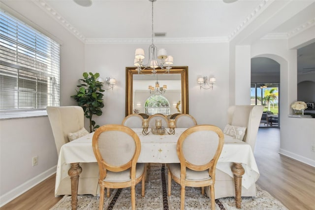 dining room featuring ornamental molding, a notable chandelier, and wood-type flooring