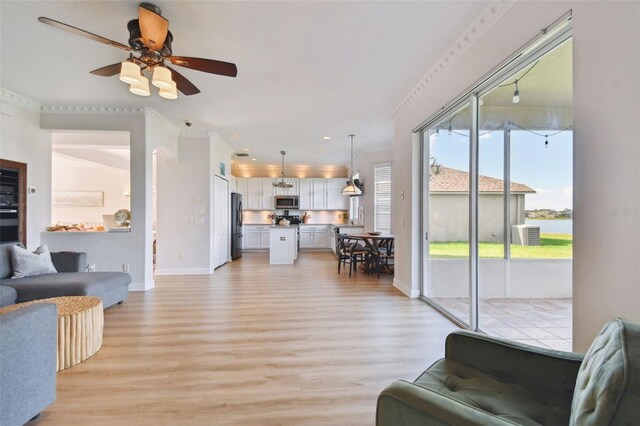 living room with ceiling fan, light hardwood / wood-style flooring, and crown molding