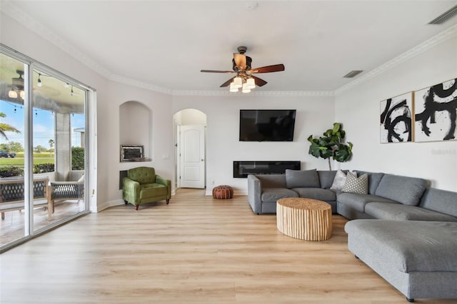 living room with light wood finished floors, visible vents, and a glass covered fireplace