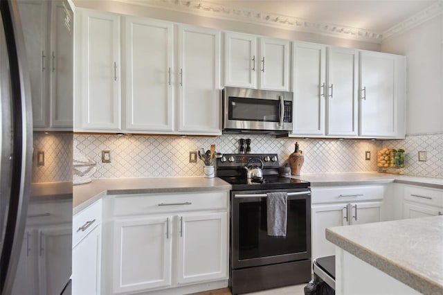 kitchen featuring backsplash, white cabinetry, stainless steel appliances, and ornamental molding