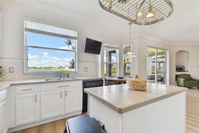 kitchen featuring white cabinetry, dishwasher, decorative light fixtures, and sink