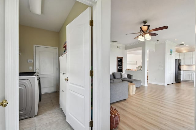 laundry area with light tile patterned floors, washer / clothes dryer, ceiling fan, and crown molding