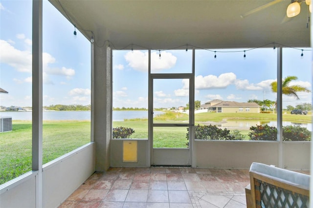 unfurnished sunroom featuring a water view and ceiling fan