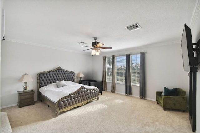 carpeted bedroom with baseboards, a ceiling fan, visible vents, and crown molding