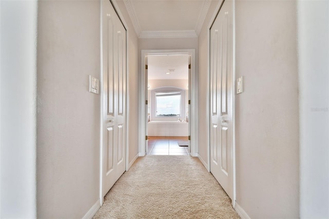 hallway featuring crown molding and light carpet