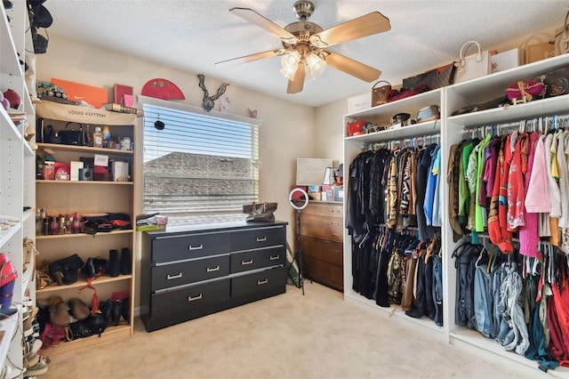 spacious closet with light carpet and ceiling fan