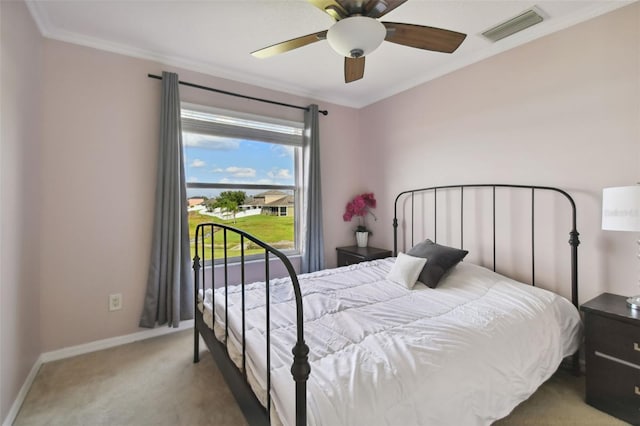 carpeted bedroom featuring ceiling fan and crown molding