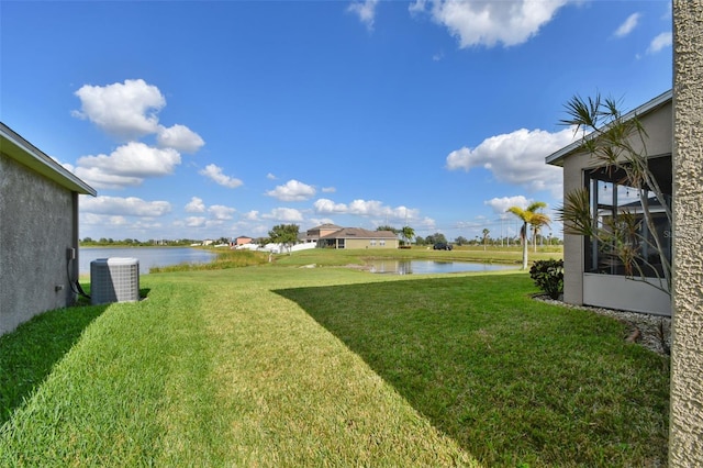 view of yard with a water view and central air condition unit