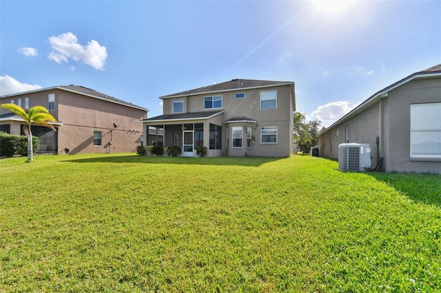 rear view of house featuring a yard, cooling unit, and a sunroom