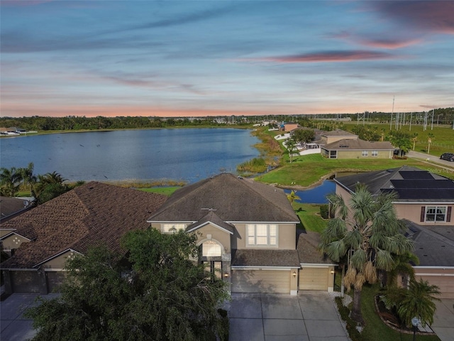 aerial view at dusk featuring a water view