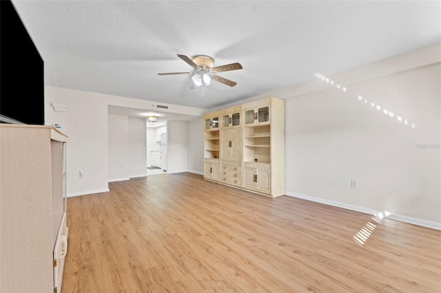 unfurnished living room with ceiling fan, light hardwood / wood-style floors, and a textured ceiling