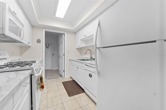 kitchen with white cabinetry, sink, a raised ceiling, light stone counters, and white appliances