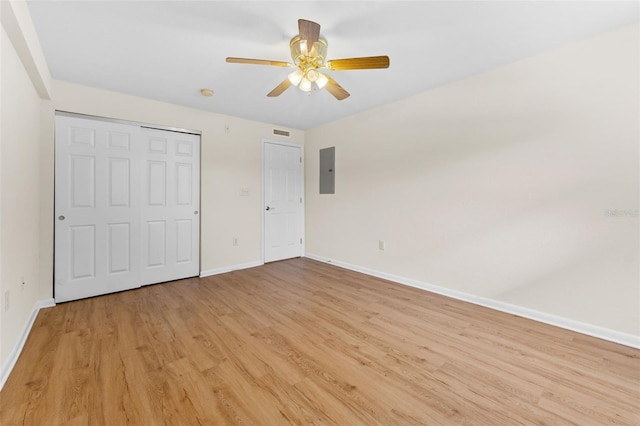 unfurnished bedroom with electric panel, ceiling fan, and light wood-type flooring