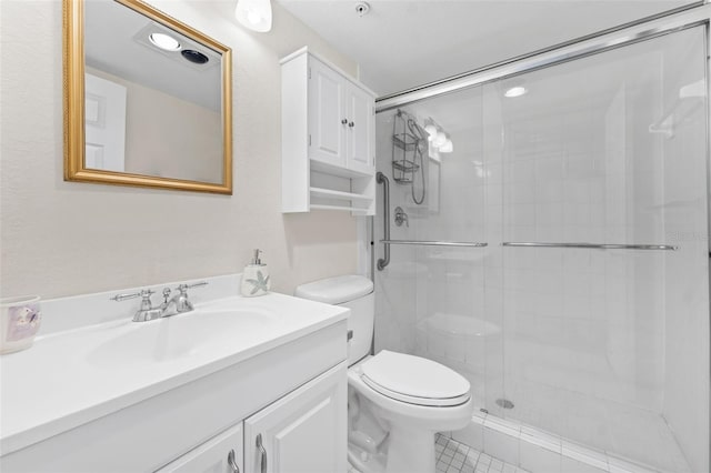 bathroom featuring tile patterned flooring, vanity, toilet, and a shower with door