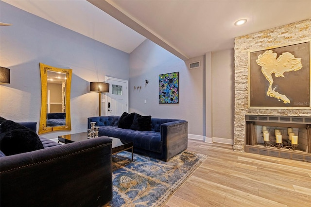 living room with lofted ceiling, wood-type flooring, and a fireplace