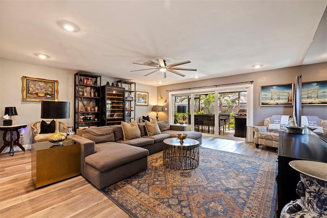 living room featuring light wood-type flooring and ceiling fan