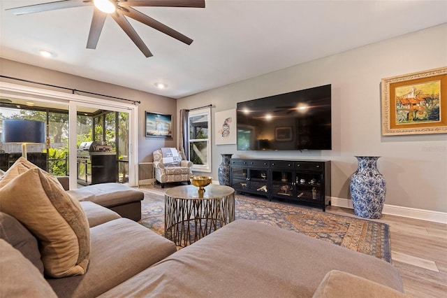 living room featuring light hardwood / wood-style flooring and ceiling fan