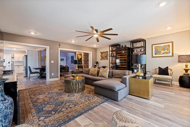 living room with ceiling fan and light hardwood / wood-style flooring