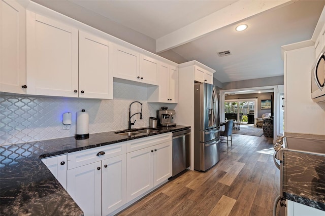 kitchen with sink, stainless steel appliances, tasteful backsplash, wood-type flooring, and white cabinets